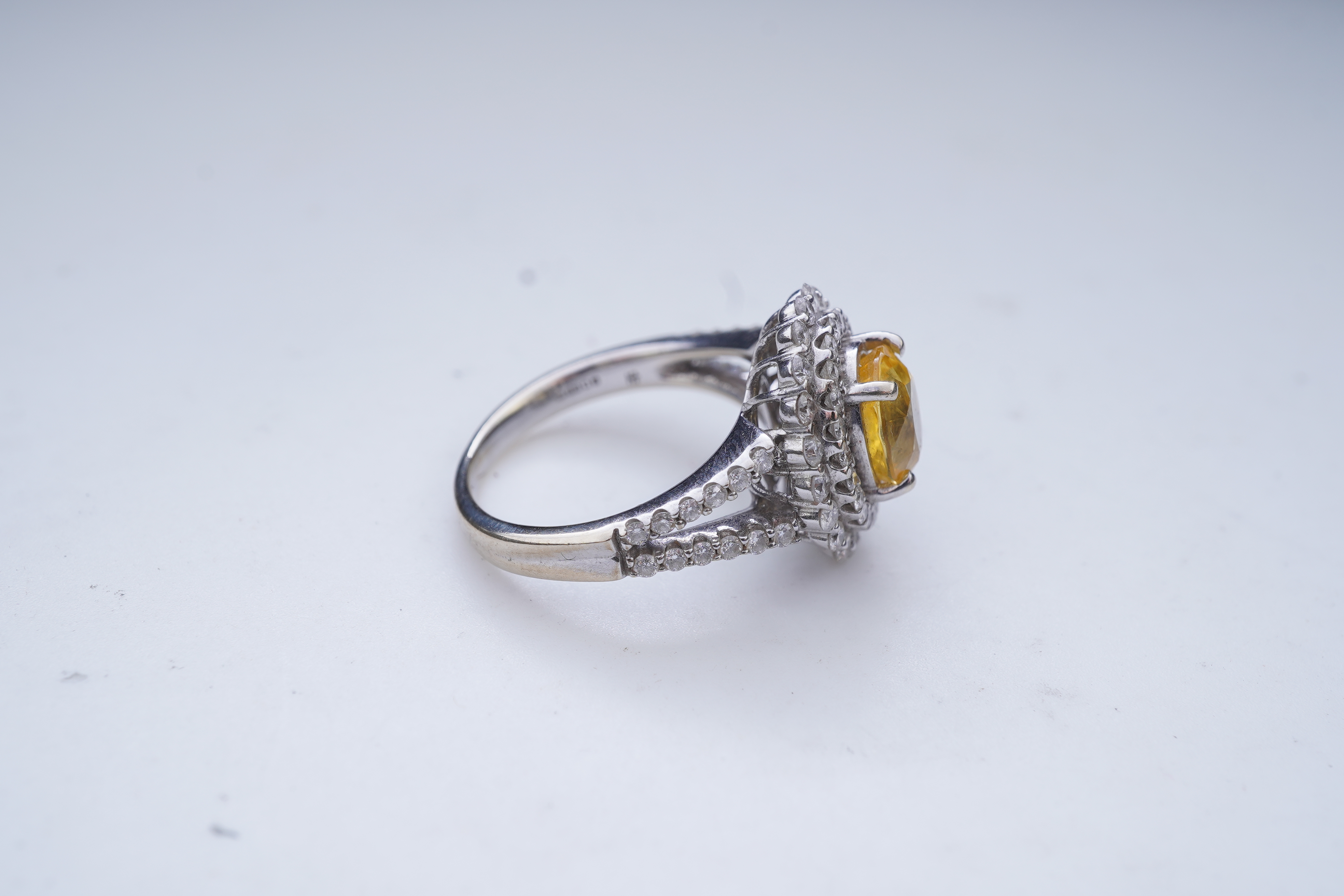 A yellow sapphire and diamond ring